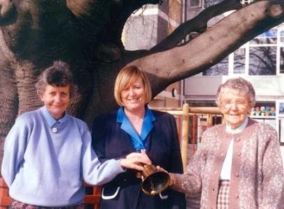 three women ringing a bell