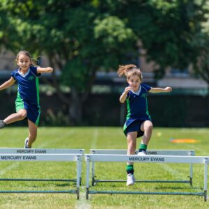girls running over hurdles